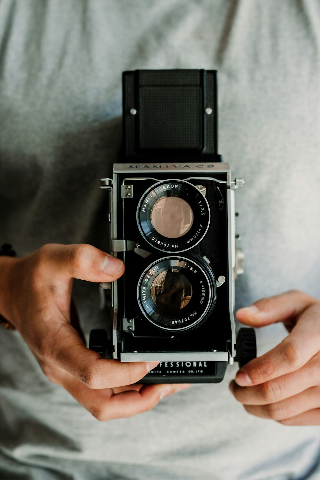 Close up of hands holding a vintage film camera