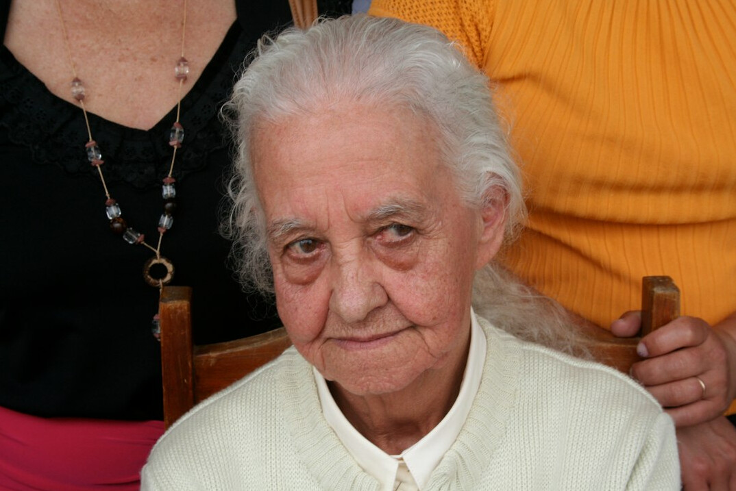 Portrait of an older Latina woman with gray hair smiling