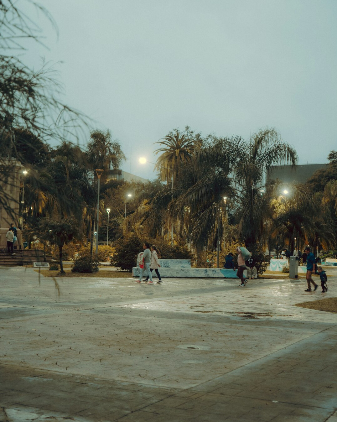 People gathering in a city plaza in the evening