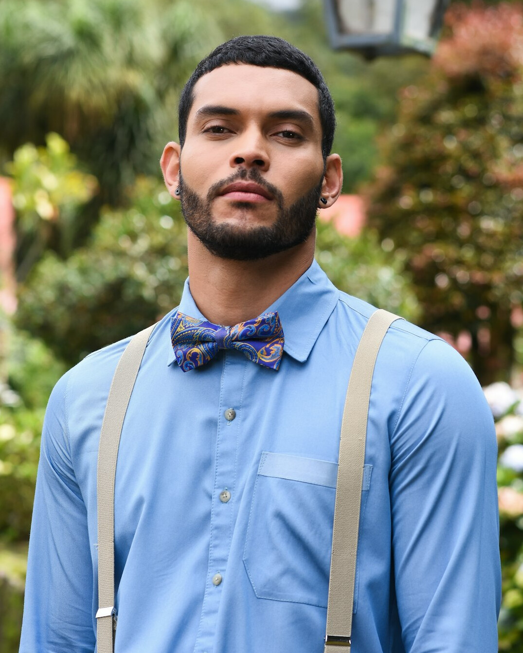 Portrait of a young Latino man with beard and camera strap
