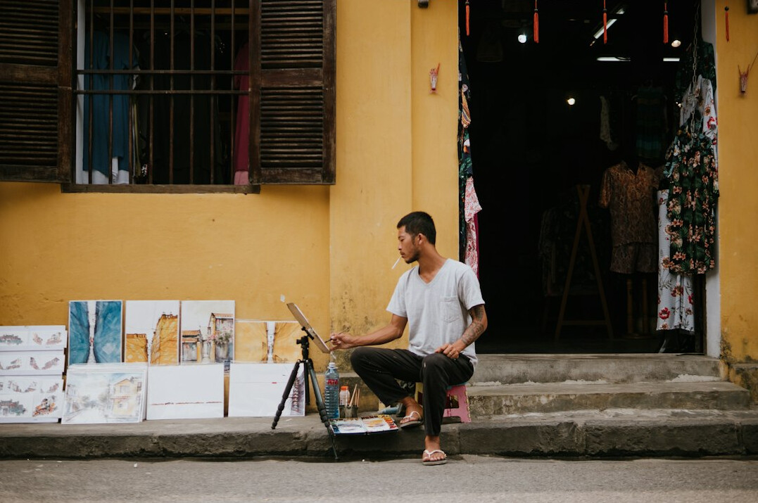 Person editing street photography on a laptop with camera nearby